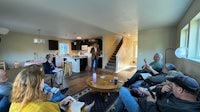 a group of people sitting around a table in a living room